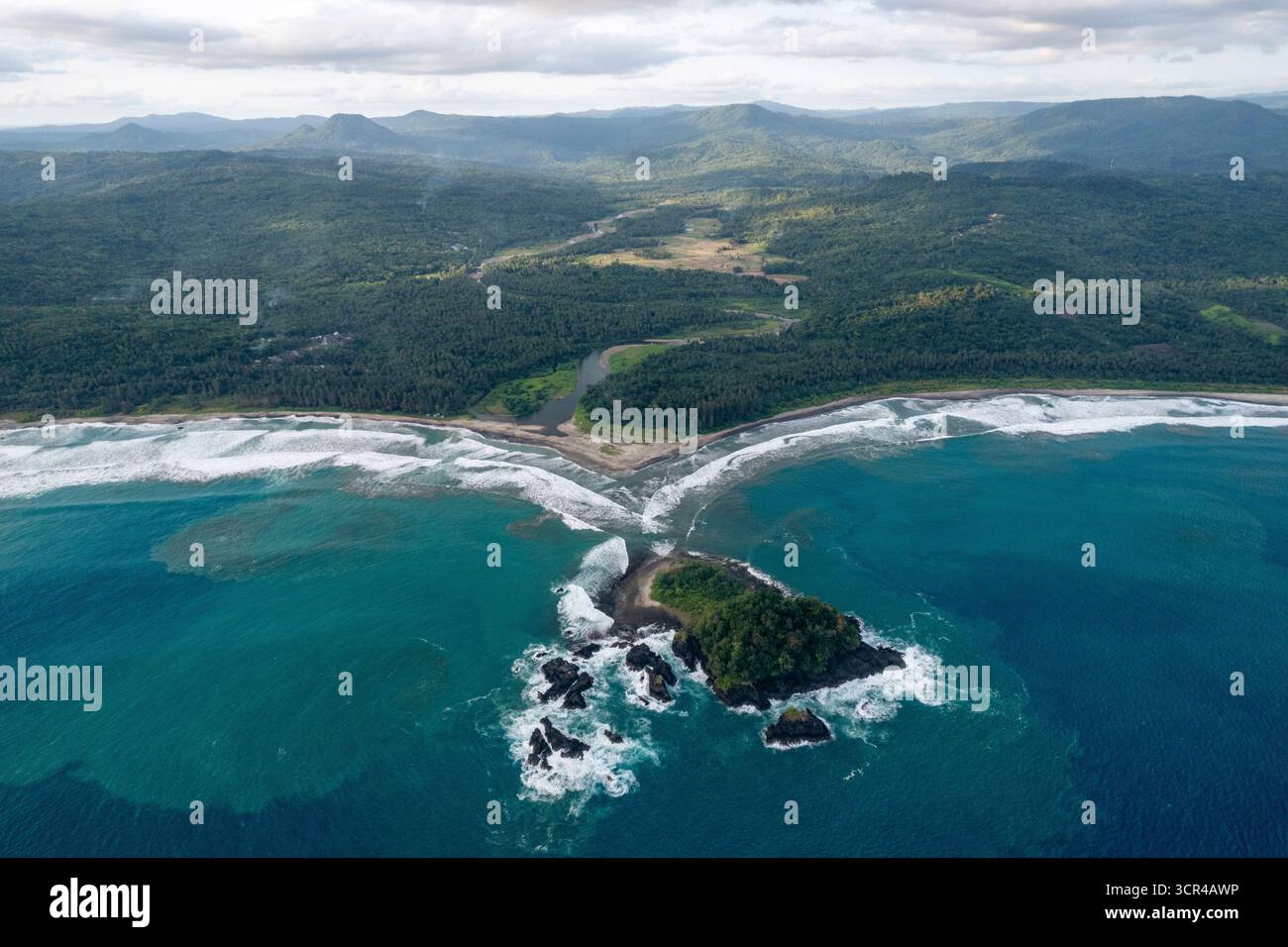 Vue aérienne d'un littoral avec des vagues, des collines verdoyantes et une petite île. Nias du Sud, Sumatra du Nord, Indonésie Banque D'Images Vue aérienne d'un littoral avec des vagues, des collines verdoyantes et une petite île. Nias du Sud, Sumatra du Nord, Indonésie Banque D'Images