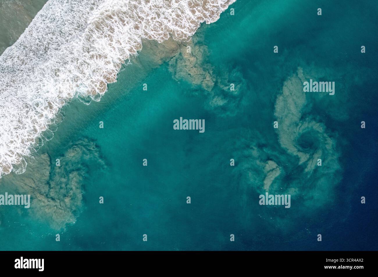 Vue aérienne des vagues de l'océan qui s'écrasent sur une plage de sable avec des plans d'eau tourbillonnants. Nias du Sud, Sumatra du Nord, Indonésie Banque D'Images Vue aérienne des vagues de l'océan qui s'écrasent sur une plage de sable avec des plans d'eau tourbillonnants. Nias du Sud, Sumatra du Nord, Indonésie Banque D'Images