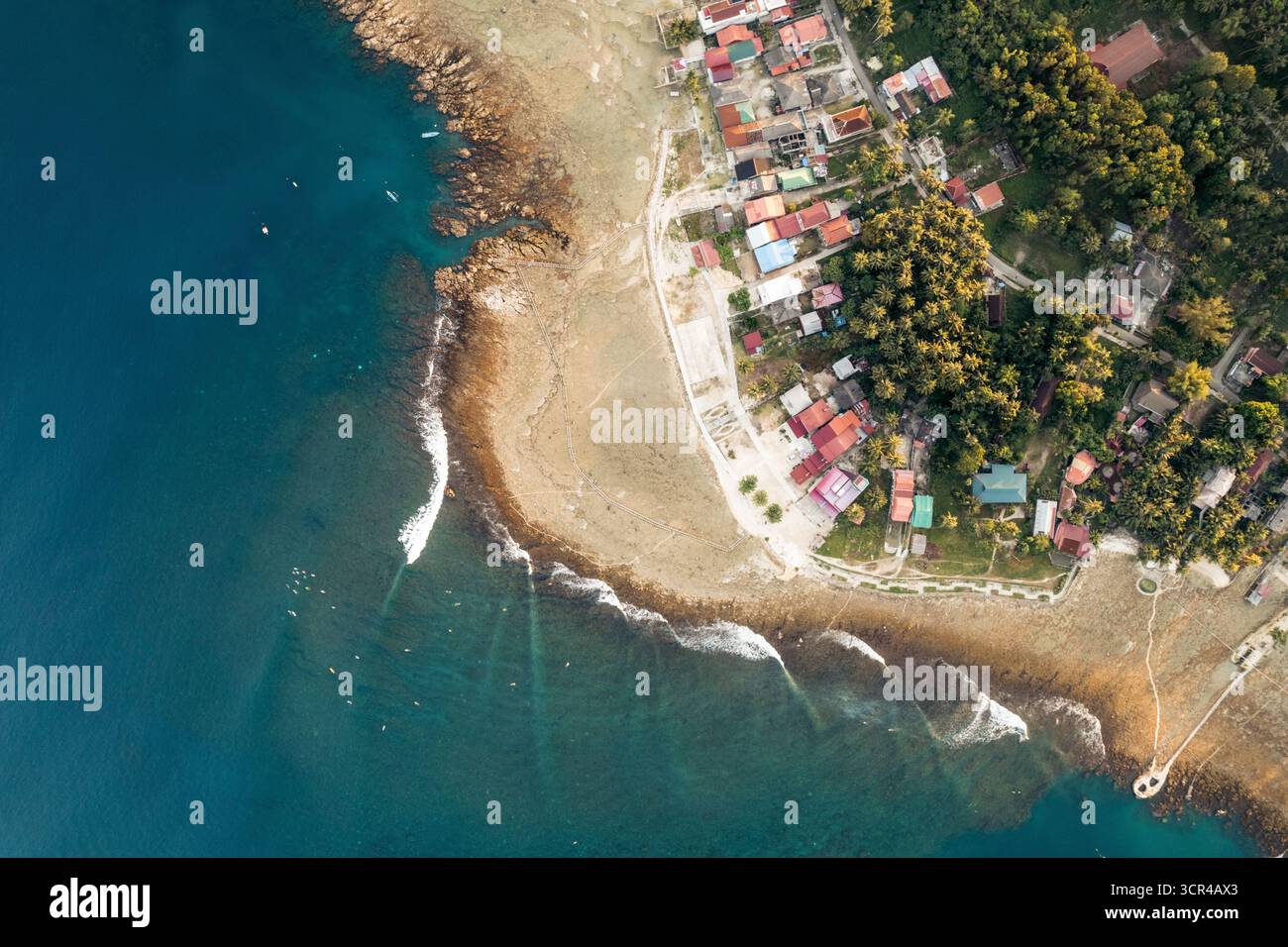 Vue aérienne d'un village côtier avec des maisons colorées et une verdure luxuriante au bord de l'océan. Nias du Sud, Sumatra du Nord, Indonésie Banque D'Images Vue aérienne d'un village côtier avec des maisons colorées et une verdure luxuriante au bord de l'océan. Nias du Sud, Sumatra du Nord, Indonésie Banque D'Images