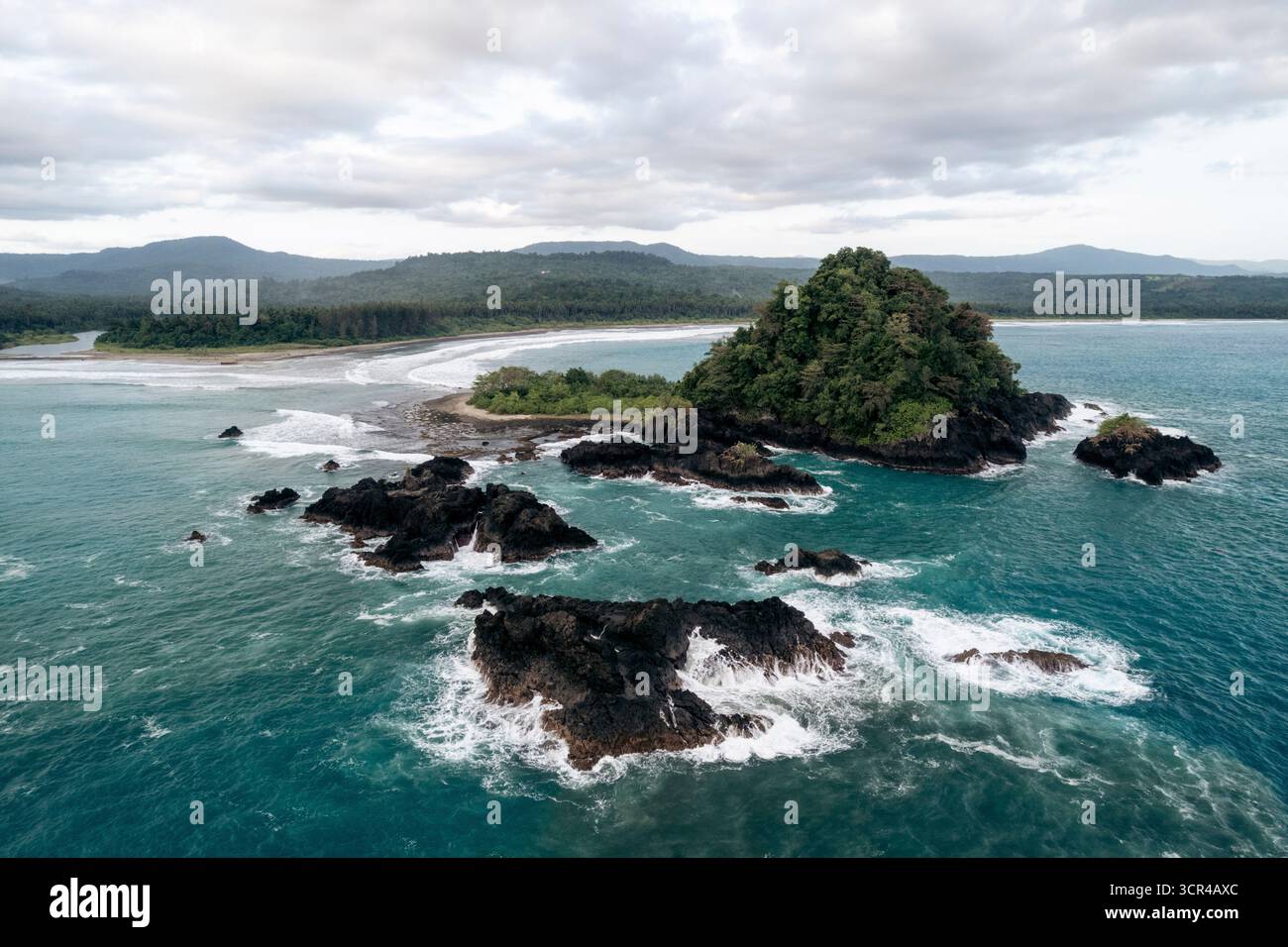 Vue aérienne d'une île tropicale avec une végétation luxuriante entourée d'un océan turquoise et de rives rocheuses. Nias du Sud, Sumatra du Nord, Indonésie Banque D'Images Vue aérienne d'une île tropicale avec une végétation luxuriante entourée d'un océan turquoise et de rives rocheuses. Nias du Sud, Sumatra du Nord, Indonésie Banque D'Images