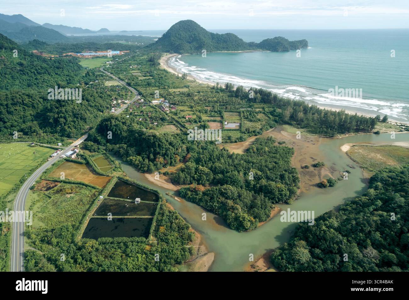 Vue aérienne du paysage côtier luxuriant avec rivière sinueuse et montagnes lointaines. Régence d'Aceh Jaya, Aceh, Sumatra, Indonésie Banque D'Images Vue aérienne du paysage côtier luxuriant avec rivière sinueuse et montagnes lointaines. Régence d'Aceh Jaya, Aceh, Sumatra, Indonésie Banque D'Images