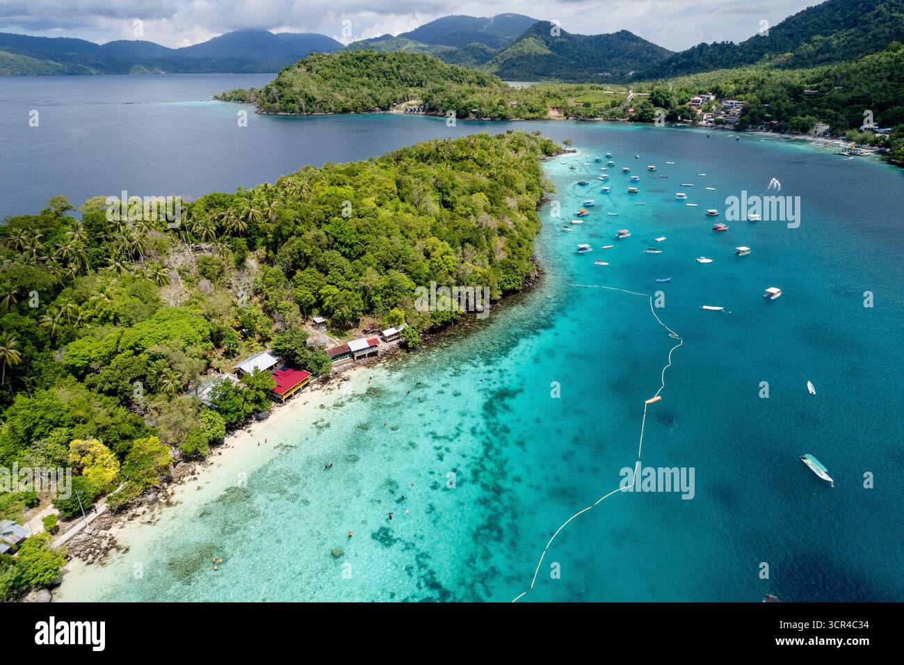 Vue aérienne de l'île tropicale avec verdure luxuriante, eau turquoise et bateaux dispersés. Sabang, Aceh, Sumatra, Indonésie Banque D'Images Vue aérienne de l'île tropicale avec verdure luxuriante, eau turquoise et bateaux dispersés. Sabang, Aceh, Sumatra, Indonésie Banque D'Images