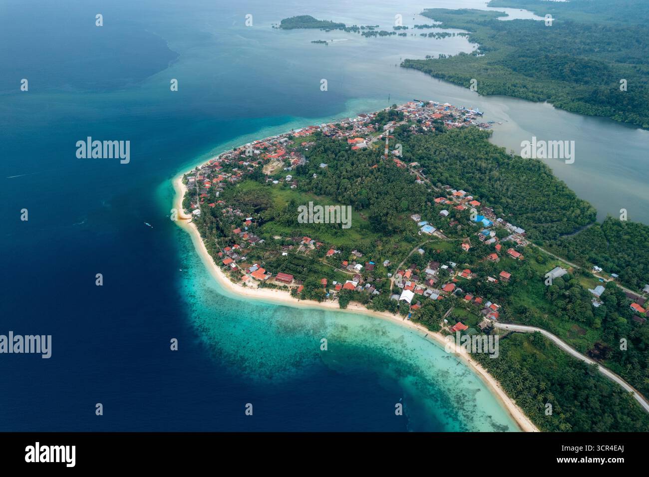 Vue aérienne d'un village côtier avec océan vibrant et verdure luxuriante. Région du village de Sipora, Mentawai, Sumatra Ouest, Indonésie Banque D'Images Vue aérienne d'un village côtier avec océan vibrant et verdure luxuriante. Région du village de Sipora, Mentawai, Sumatra Ouest, Indonésie Banque D'Images