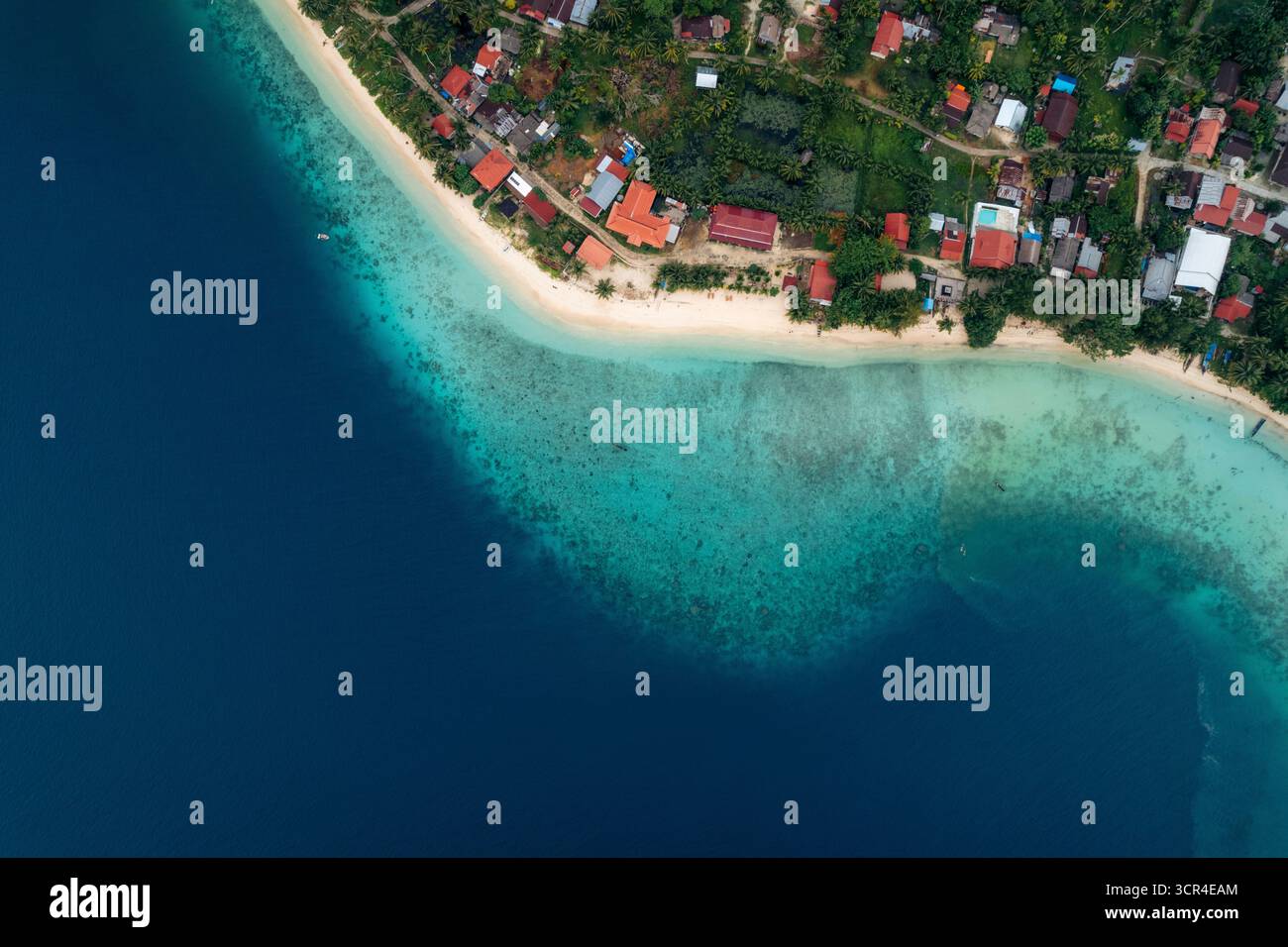 Vue aérienne d'un village côtier avec océan vibrant et verdure luxuriante. Région du village de Sipora, Mentawai, Sumatra Ouest, Indonésie Banque D'Images Vue aérienne d'un village côtier avec océan vibrant et verdure luxuriante. Région du village de Sipora, Mentawai, Sumatra Ouest, Indonésie Banque D'Images