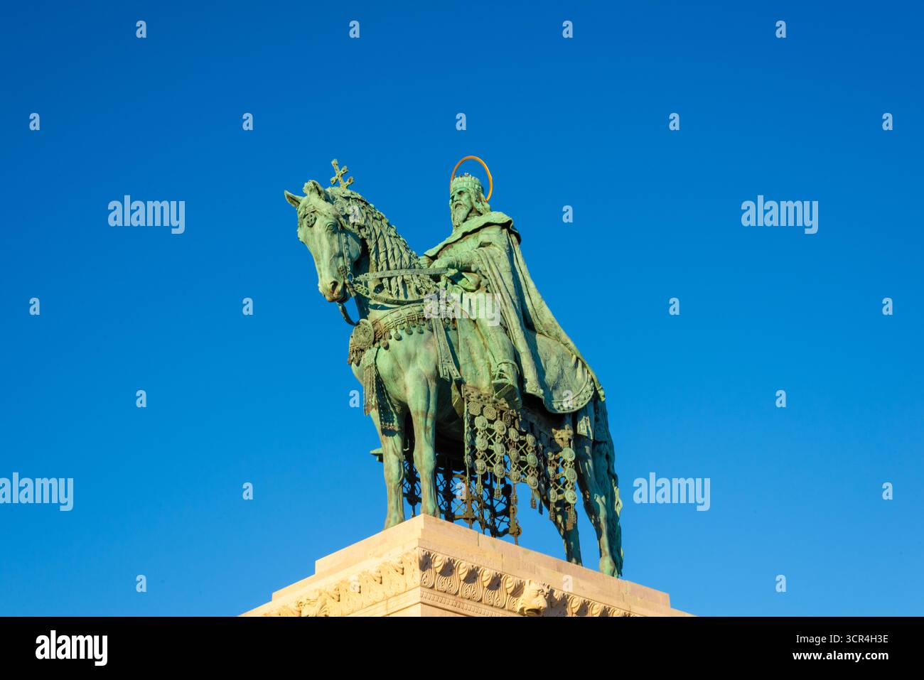 Statue équestre en bronze du roi Étienne Ier de Hongrie avec couronne et halo contre le ciel bleu vibrant, célèbre monument historique à Budapest. Banque D'Images