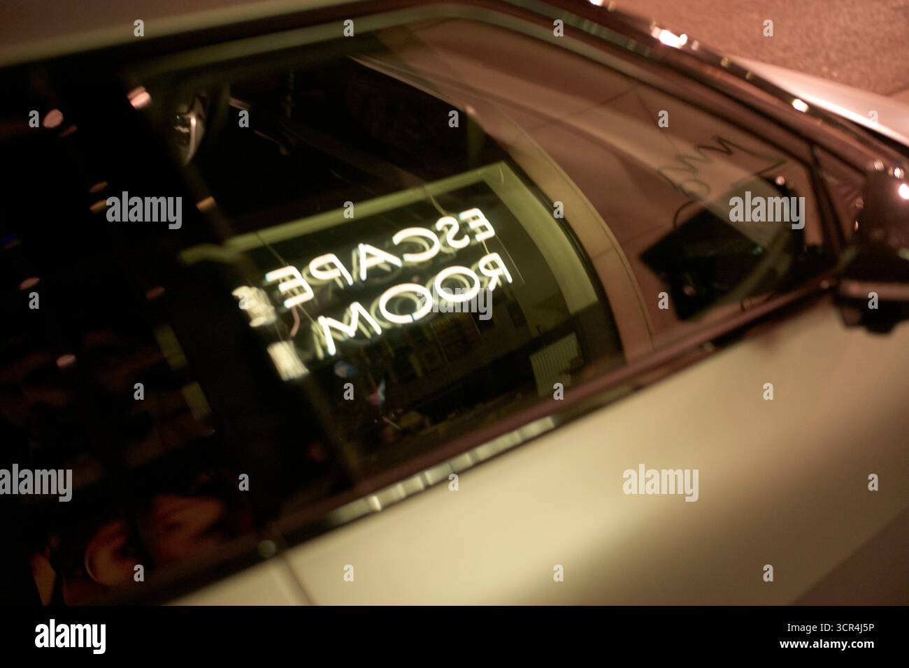 Enseigne au néon reflétant dans une fenêtre de voiture, affichant Escape Room dans un cadre faiblement éclairé. Anvers, Belgique Banque D'Images
