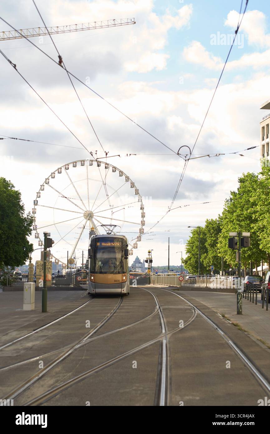 Tram sur la rue de la ville avec grande roue et grues de construction en arrière-plan. Bruxelles, Belgique Banque D'Images
