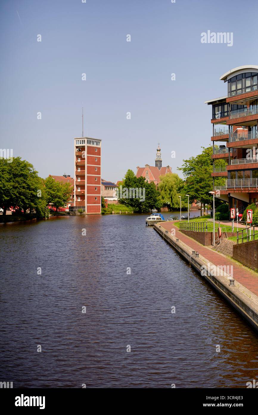 Un canal calme avec des bâtiments et une tour d'église dans un cadre urbain ensoleillé. Mer du Nord, Allemagne Banque D'Images