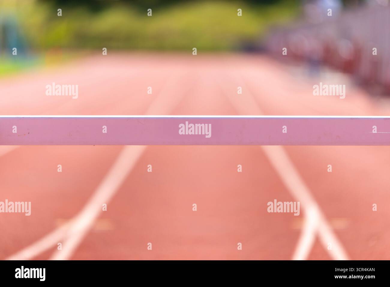 Gros plan d'une haie athlétique sur une piste de course rouge avec arrière flou Banque D'Images