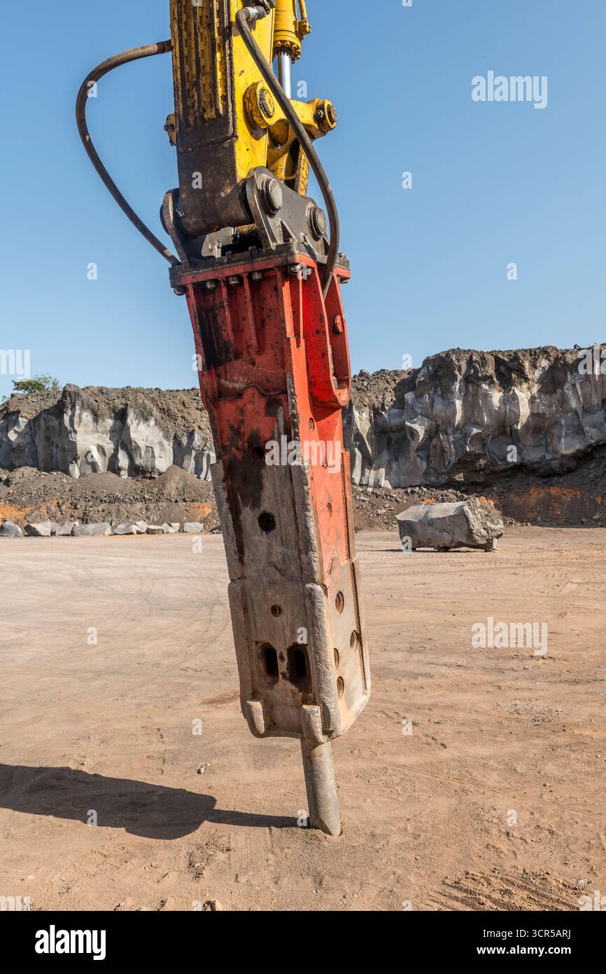 Marteau hydraulique ou marteau à percussion fixé à une excavatrice dans une carrière de roche basaltique volcanique, sur les pentes de l'Etna en Sicile Banque D'Images