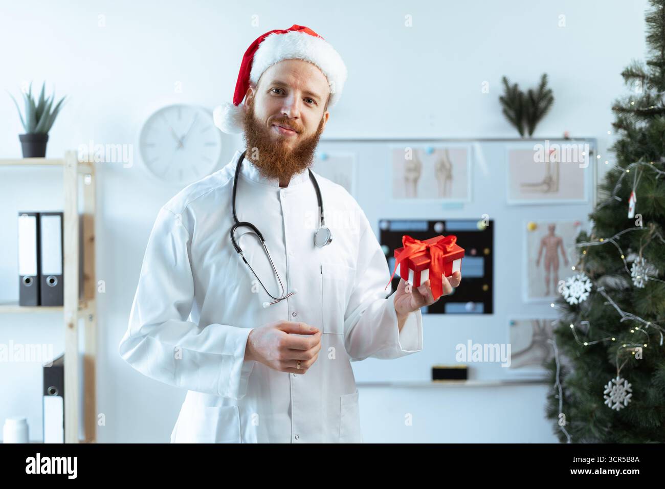 Médecin tenant une boîte-cadeau regardant la caméra à l'hôpital pendant le quart de Noël. copier l'espace Banque D'Images