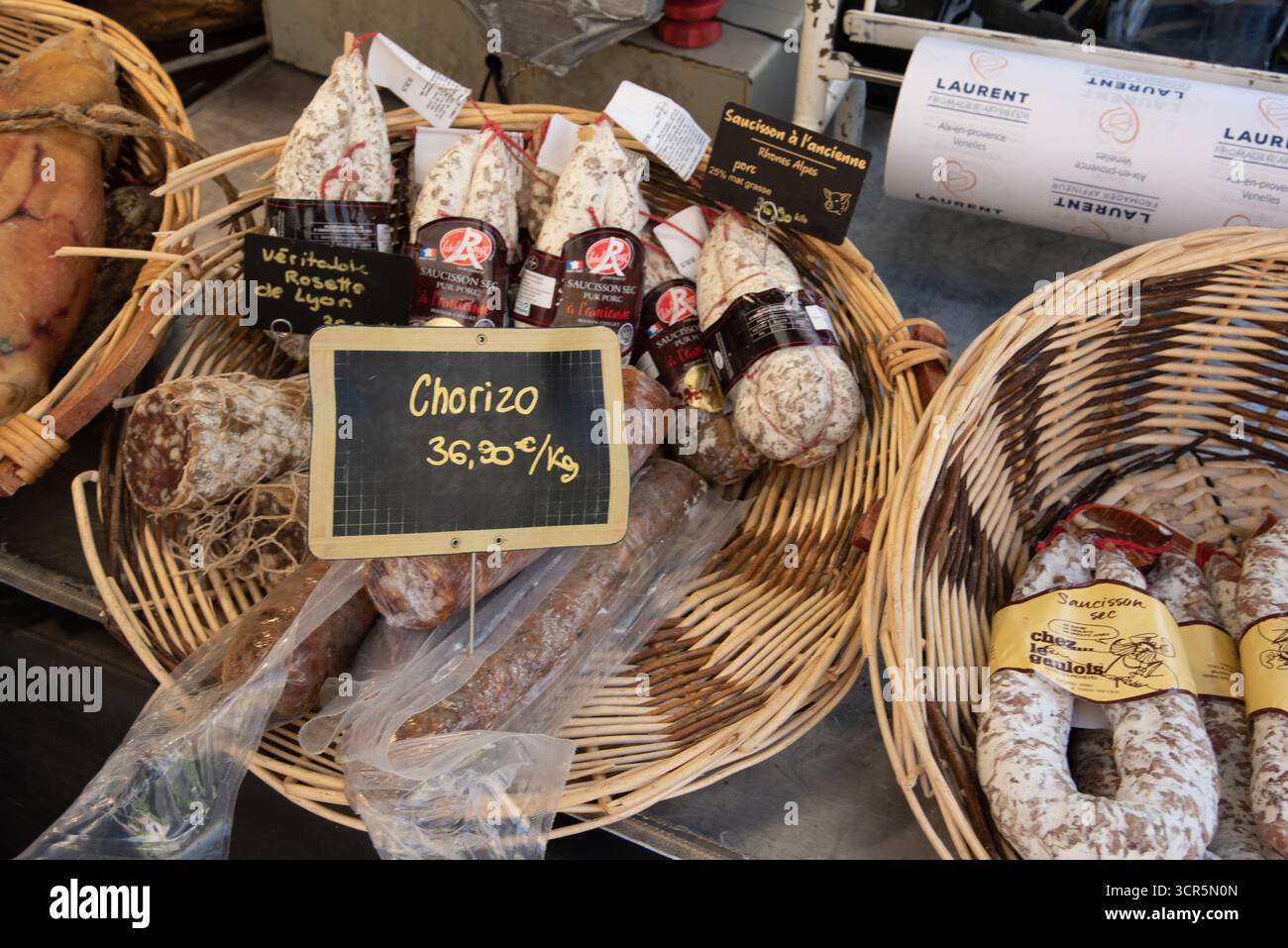 Exposition de Chorizo, une saucisse de porc, dans un panier en osier à vendre sur le stand du marché à Aix-en-Provence Provence France Banque D'Images