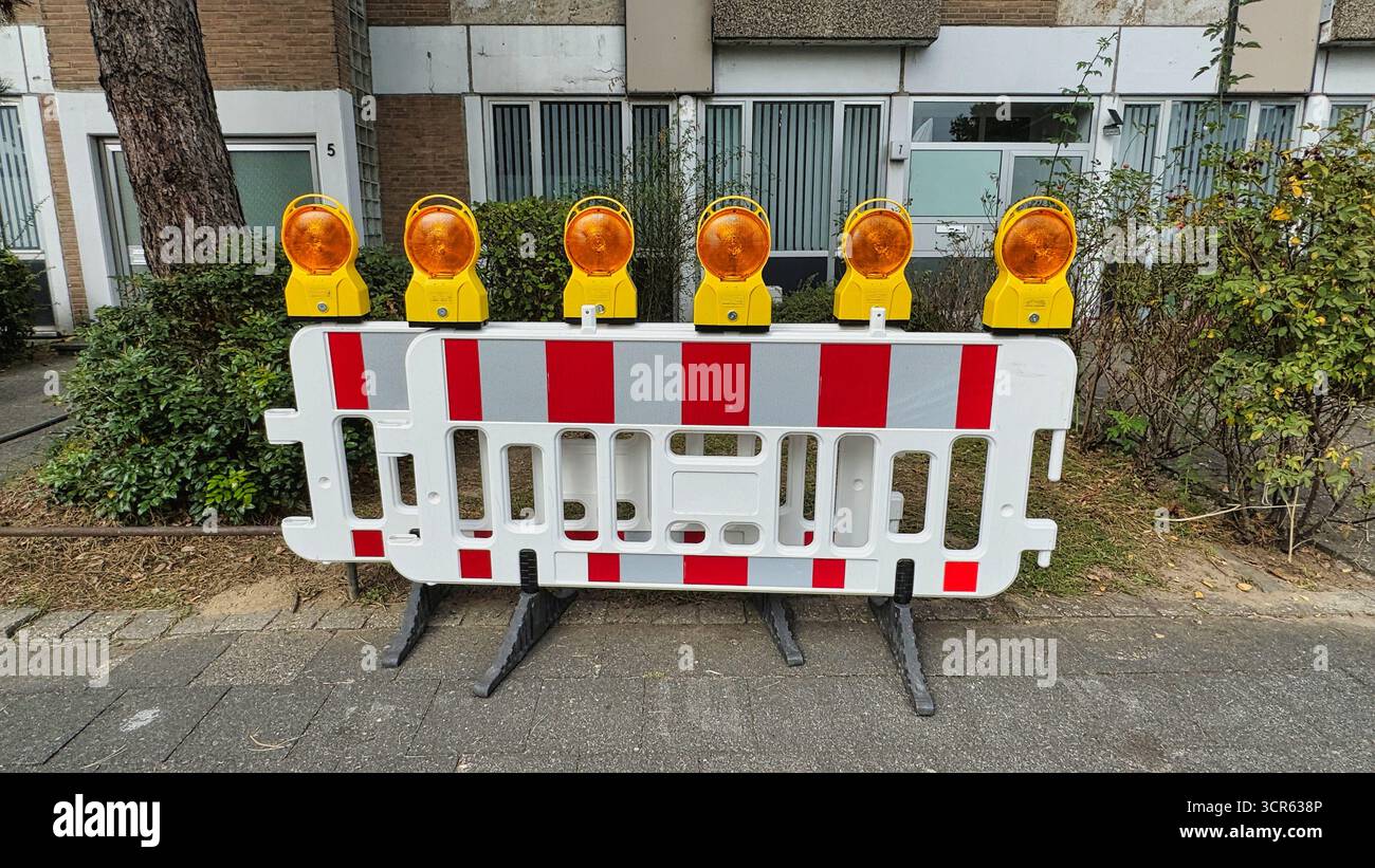 Barrière de construction de route avec feux d'avertissement, clôture en plastique rayé pour la sécurité routière et la protection de la rue Banque D'Images