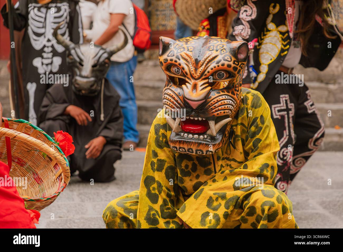 Deux personnes portant des masques et des costumes, l'un d'un jaguar et l'autre d'un taureau, agenouillées pendant une danse folklorique lors d'une fête mexicaine. Banque D'Images