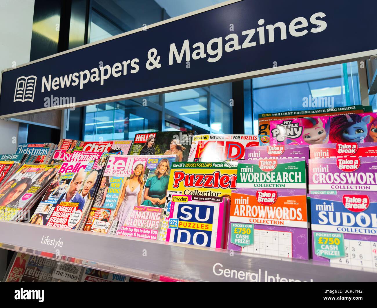 Londres, Royaume-Uni - 26 septembre 2025 : dynamique magazine Aisle présentant des mots croisés de puzzle et des titres de style de vie sous une enseigne de journaux et magazines. Banque D'Images