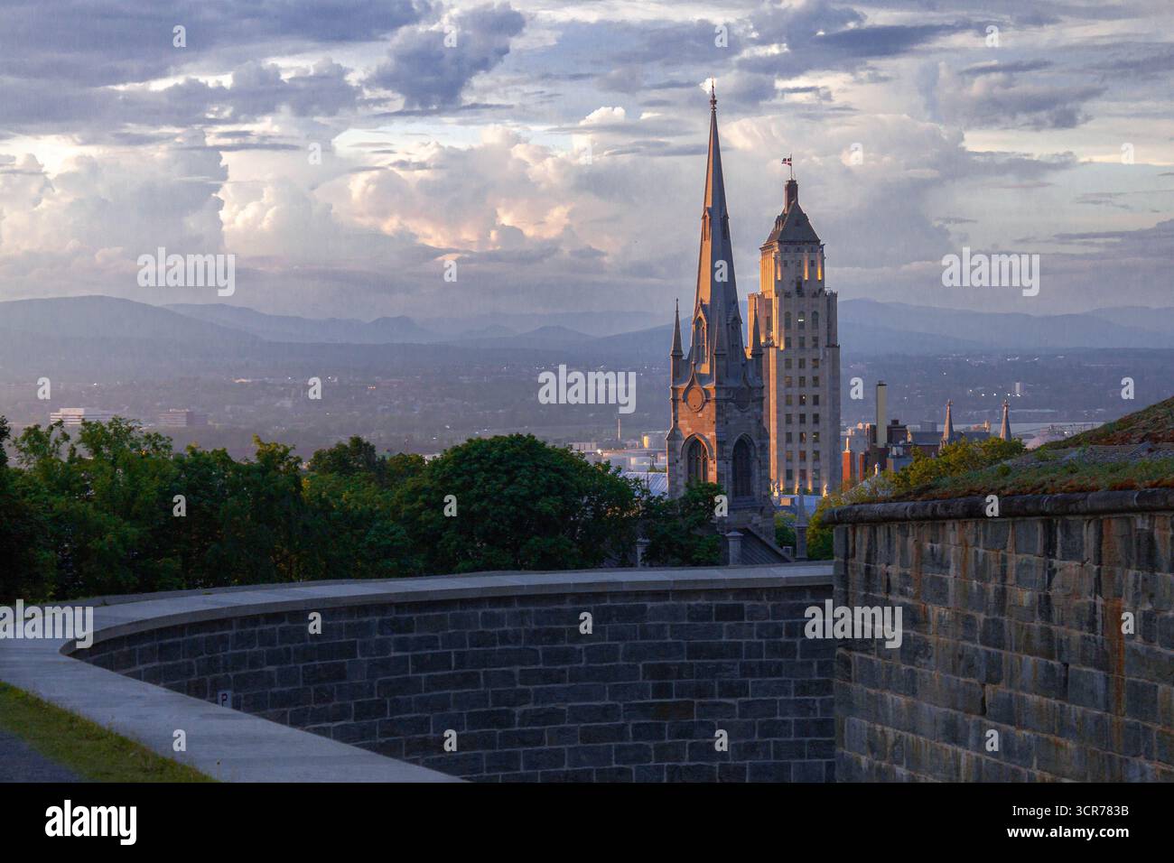 Horizon de Québec avec Price Building et clocher d'église au coucher du soleil, mur de la ville historique au premier plan, nuages spectaculaires, architecture de voyage Canada Banque D'Images