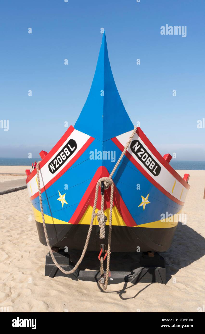 Vue de face de la proue d'un bateau de pêche décoré de couleurs vives sur la plage de Nazaré, Portugal Banque D'Images