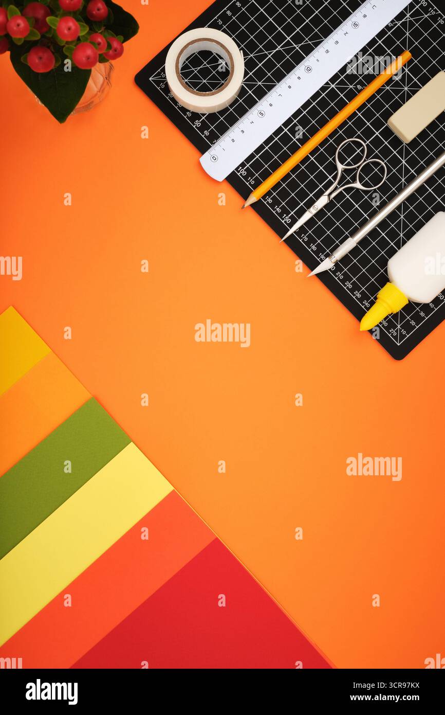 Espace de travail pour l'artisanat papier. Feuilles colorées, tapis de découpe, crayon, couteau, gomme. Espace pour le texte. Banque D'Images