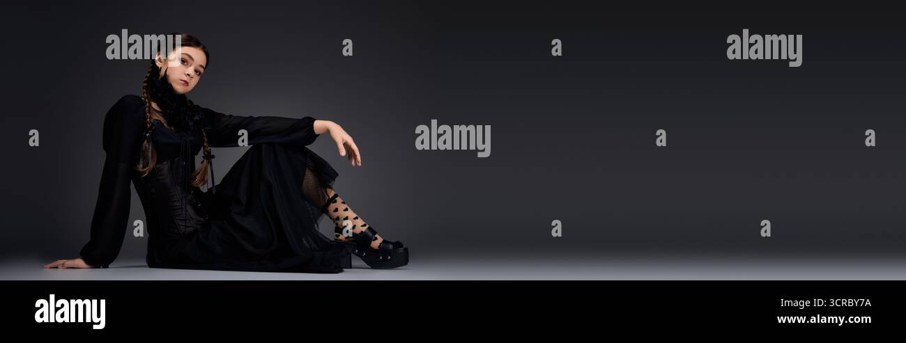 Une fille habillée comme un personnage gothique du mercredi met en valeur son esprit d'Halloween dans le style, bannière Banque D'Images