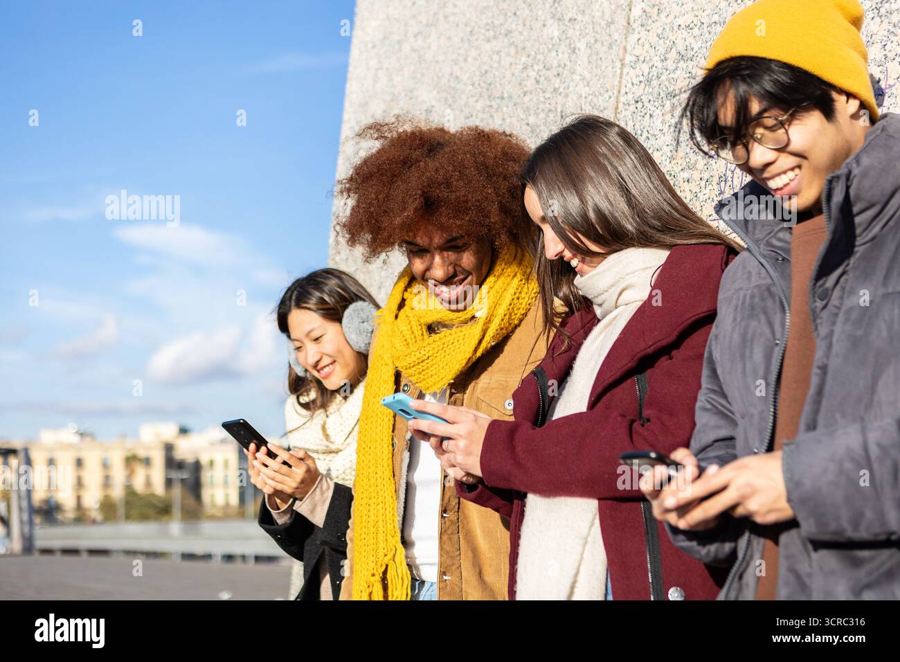 Des amis multiraciaux rient ensemble en regardant du contenu sur les réseaux sociaux sur leur téléphone Banque D'Images