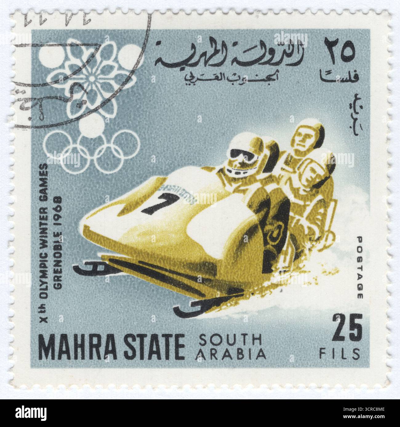 YÉMEN, MAHRA - 1967 : timbre-poste de 25 fils représentant quatre hommes Bobsleigh, un sport d'hiver dans lequel une équipe d'un pilote, deux pousseurs et un frekeman poussent puis roulent sur un traîneau le long d'une piste sinueuse et glacée. La course commence par une puissante poussée de sprint pour la vitesse, suivie par le chargement de l'équipage dans le traîneau. Le pilote dirige ensuite le traîneau sur le parcours, où la vitesse peut dépasser 150 km/h. Le frekeman arrête le traîneau après la ligne d'arrivée. L'événement a fait ses débuts aux premiers Jeux olympiques d'hiver en 1924. La compétition est généralement déterminée par le temps cumulé le plus rapide sur quatre courses. Jeux Olympiques d'hiver 1968, Grenoble Banque D'Images