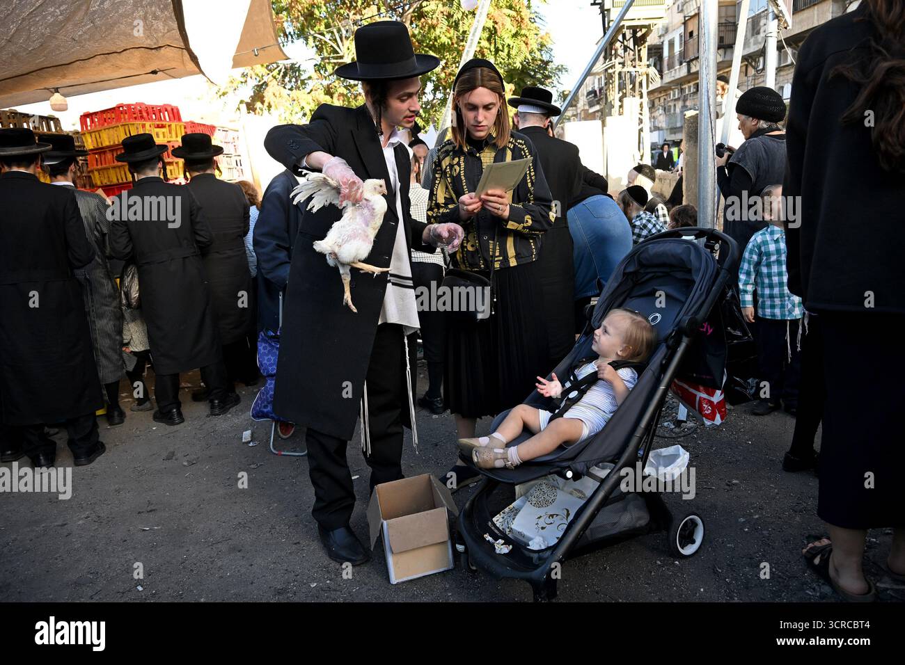 Jérusalem, Israël. 30 septembre 2025. Un homme juif ultra-orthodoxe tient un poulet tout en exécutant l'ancien rituel juif de Kapparot à Mea Shearim à Jérusalem, le mardi 30 septembre 2025. Le rituel Kapparot est exécuté avant Yom Kippour, le jour des Expiations, tandis que la personne prie en balançant un poulet sur sa tête, ce qui transfère symboliquement les péchés de l'année passée au poulet. Yom Kippour est le jour le plus Saint de l'année juive et commence au coucher du soleil le 1er octobre. Photo de Debbie Hill/ crédit : UPI/Alamy Live News Banque D'Images
