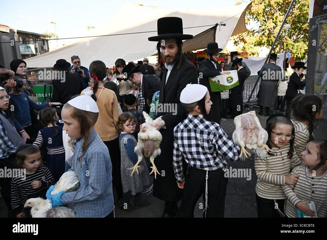 Jérusalem, Israël. 30 septembre 2025. Un juif ultra-orthodoxe tient des poulets pour l’ancien rituel juif de Kapparot à Mea Shearim à Jérusalem, le mardi 30 septembre 2025. Le rituel Kapparot est exécuté avant Yom Kippour, le jour des Expiations, tandis que la personne prie en balançant un poulet sur sa tête, ce qui transfère symboliquement les péchés de l'année passée au poulet. Yom Kippour est le jour le plus Saint de l'année juive et commence au coucher du soleil le 1er octobre. Photo de Debbie Hill/ crédit : UPI/Alamy Live News Banque D'Images