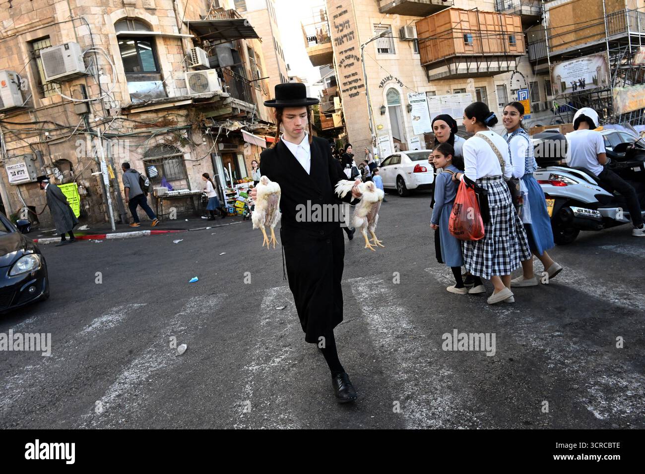 Jérusalem, Israël. 30 septembre 2025. Un homme juif ultra-orthodoxe transporte des poulets pour l’ancien rituel juif de Kapparot à Mea Shearim à Jérusalem, le mardi 30 septembre 2025. Le rituel Kapparot est exécuté avant Yom Kippour, le jour des Expiations, tandis que la personne prie en balançant un poulet sur sa tête, ce qui transfère symboliquement les péchés de l'année passée au poulet. Yom Kippour est le jour le plus Saint de l'année juive et commence au coucher du soleil le 1er octobre. Photo de Debbie Hill/ crédit : UPI/Alamy Live News Banque D'Images
