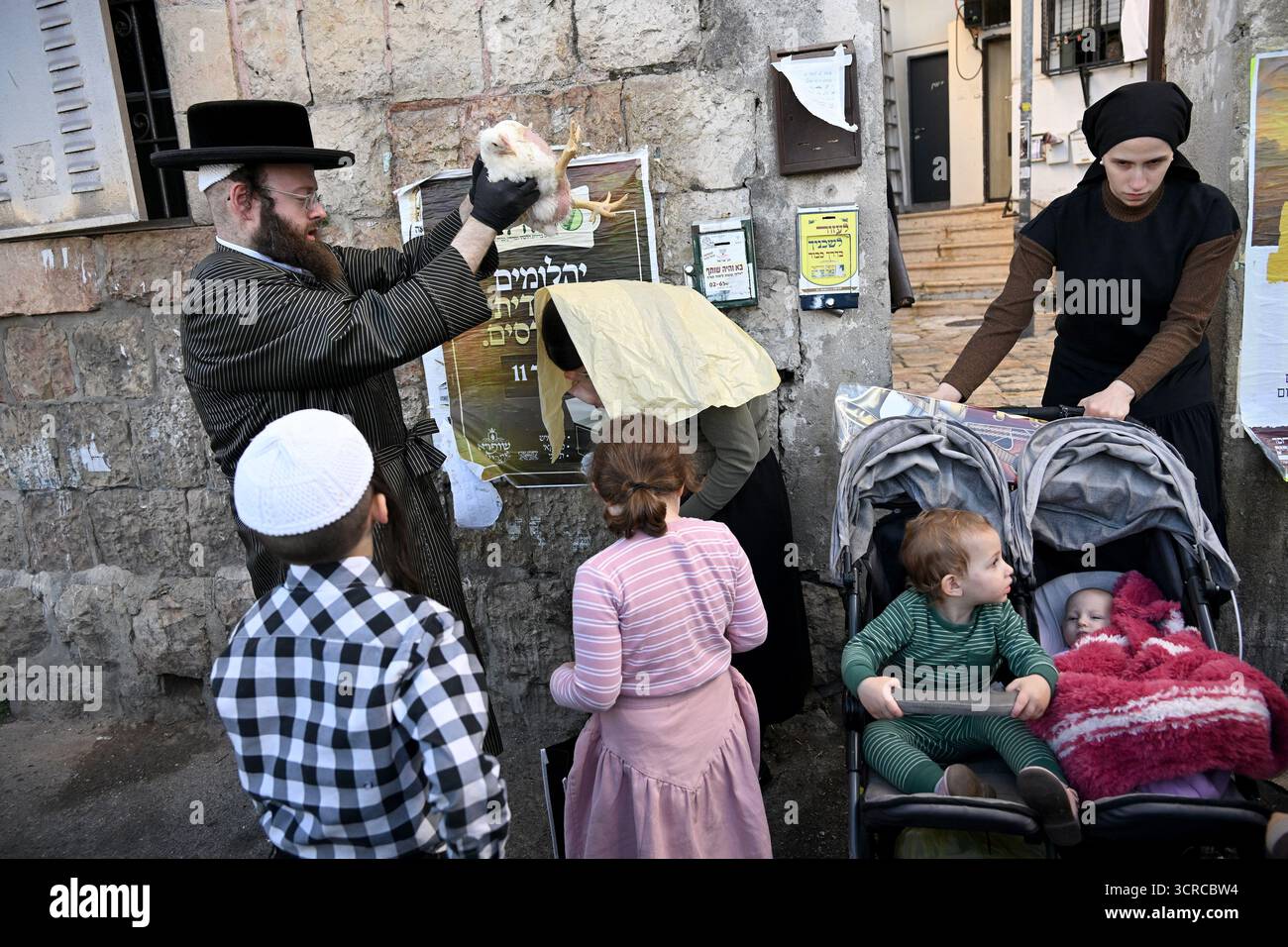 Jérusalem, Israël. 30 septembre 2025. Un homme juif ultra-orthodoxe tient un poulet au-dessus de la tête de sa femme tout en exécutant l'ancien rituel juif de Kapparot à Mea Shearim à Jérusalem, le mardi 30 septembre 2025. Le rituel Kapparot est exécuté avant Yom Kippour, le jour des Expiations, tandis que la personne prie en balançant un poulet sur sa tête, ce qui transfère symboliquement les péchés de l'année passée au poulet. Yom Kippour est le jour le plus Saint de l'année juive et commence au coucher du soleil le 1er octobre. Photo de Debbie Hill/ crédit : UPI/Alamy Live News Banque D'Images