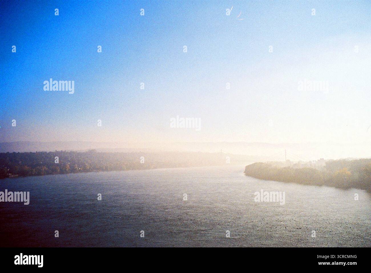 Photo analogique de la forteresse de Petrovaradin par un matin ensoleillé d'hiver. Un léger brouillard voile la ville, avec Freedom Bridge faiblement visible au loin. Banque D'Images