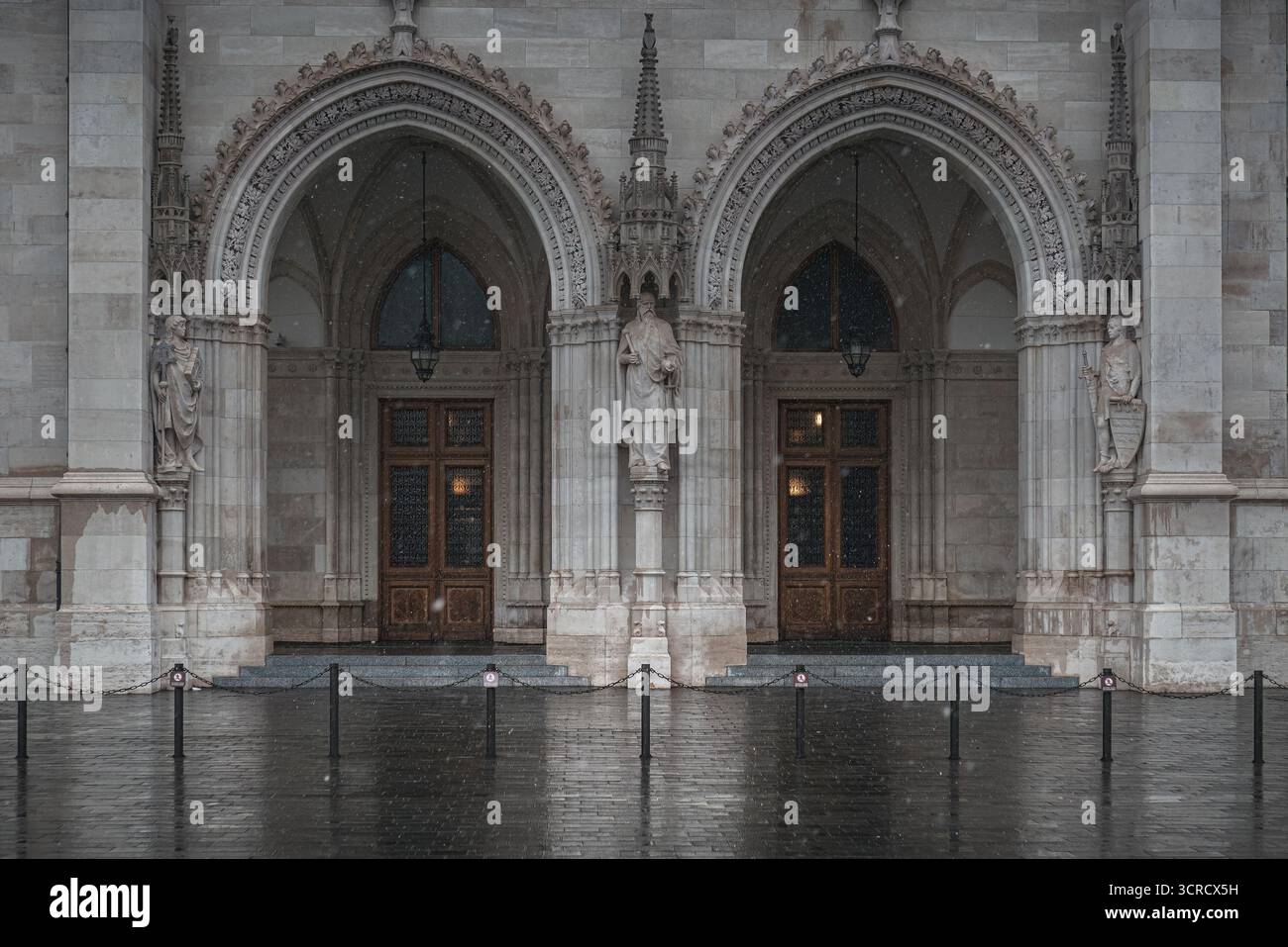 La façade imposante du bâtiment du Parlement hongrois à Budapest est mouillée par une froide journée d'hiver avec des chutes de neige Banque D'Images