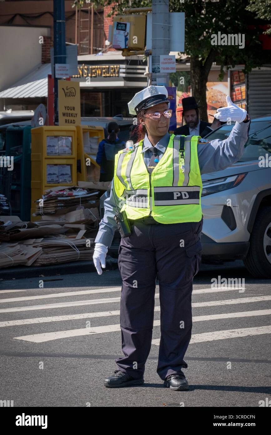 Un officier du NYPD aide à diriger la circulation lors d'une journée chargée sur Lee Avenue à Williamsburg, Brooklyn, New York. Banque D'Images