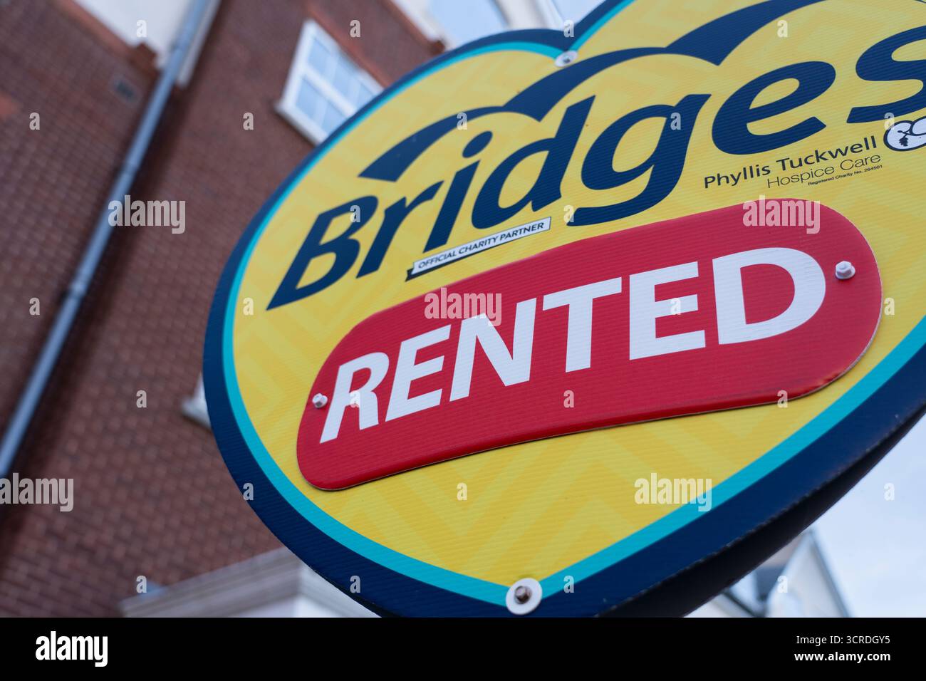 Un gros plan d'un signe d'agents immobiliers Bridges, montrant un appartement loué avec succès dans un immeuble d'appartements. Concept : coût de la vie, marché locatif, propriété Banque D'Images