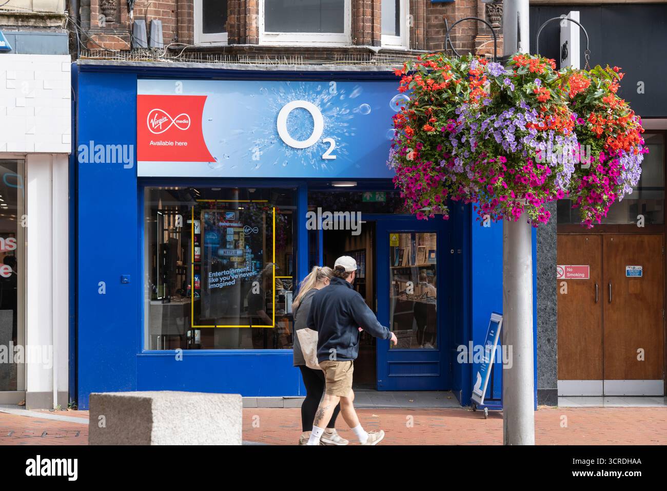 Des gens passant devant un magasin O2 sur Broad Street à Reading, au Royaume-Uni. La société de téléphonie mobile et haut débit est VMED O2 UK Limited, opérant sous le nom de Virgin Media O2 Banque D'Images