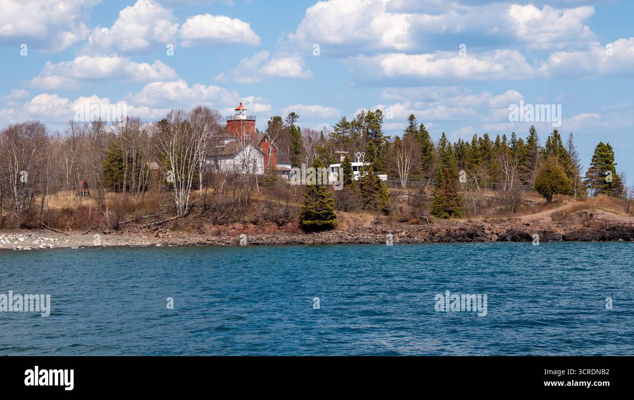 Paysage de la rive du lac supérieur dans le Minnesota à l'emplacement du phare des deux ports, et l'eau bleue et le ciel, avec des nuages blancs moelleux. Banque D'Images