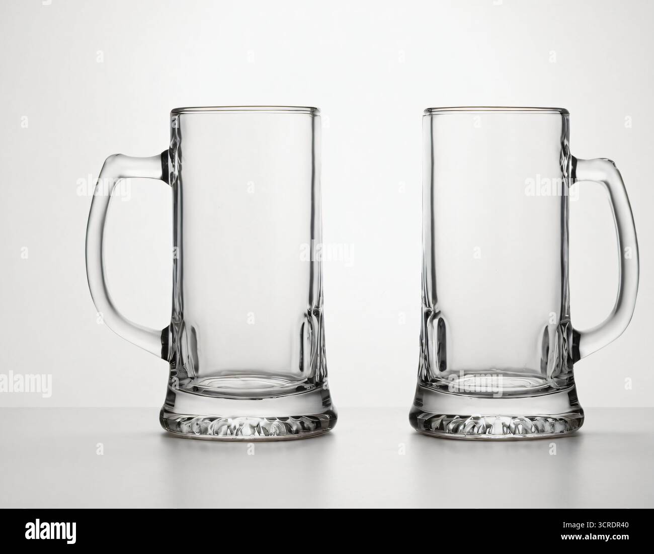 Deux tasses à bière vides en verre transparent, parfaites pour l'affichage de catalogue, la collection de barware, ou la vitrine de produit. Banque D'Images