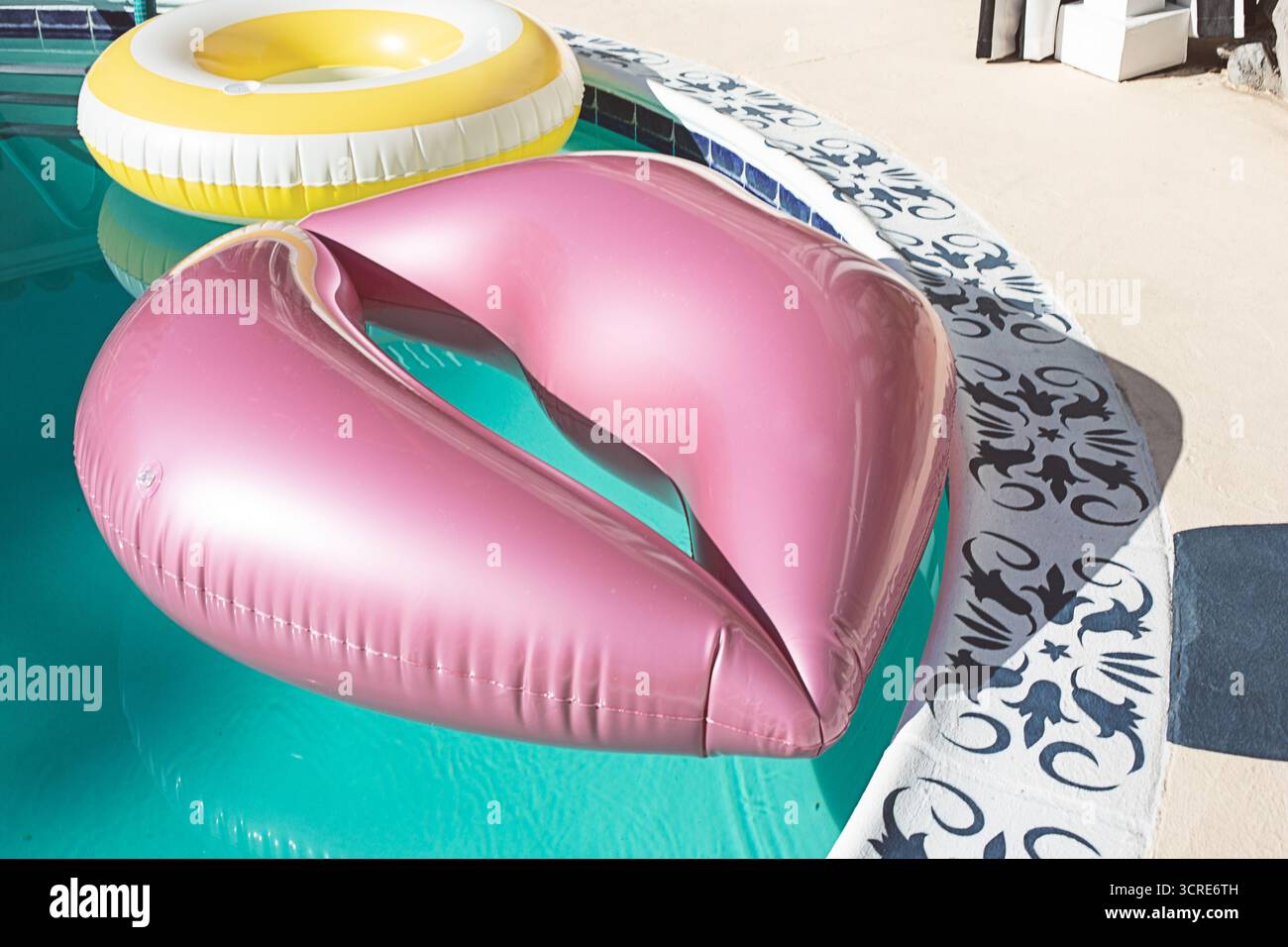 Une vue de quelques flotteurs gonflables dans une piscine, dont un en forme de lèvres. Banque D'Images