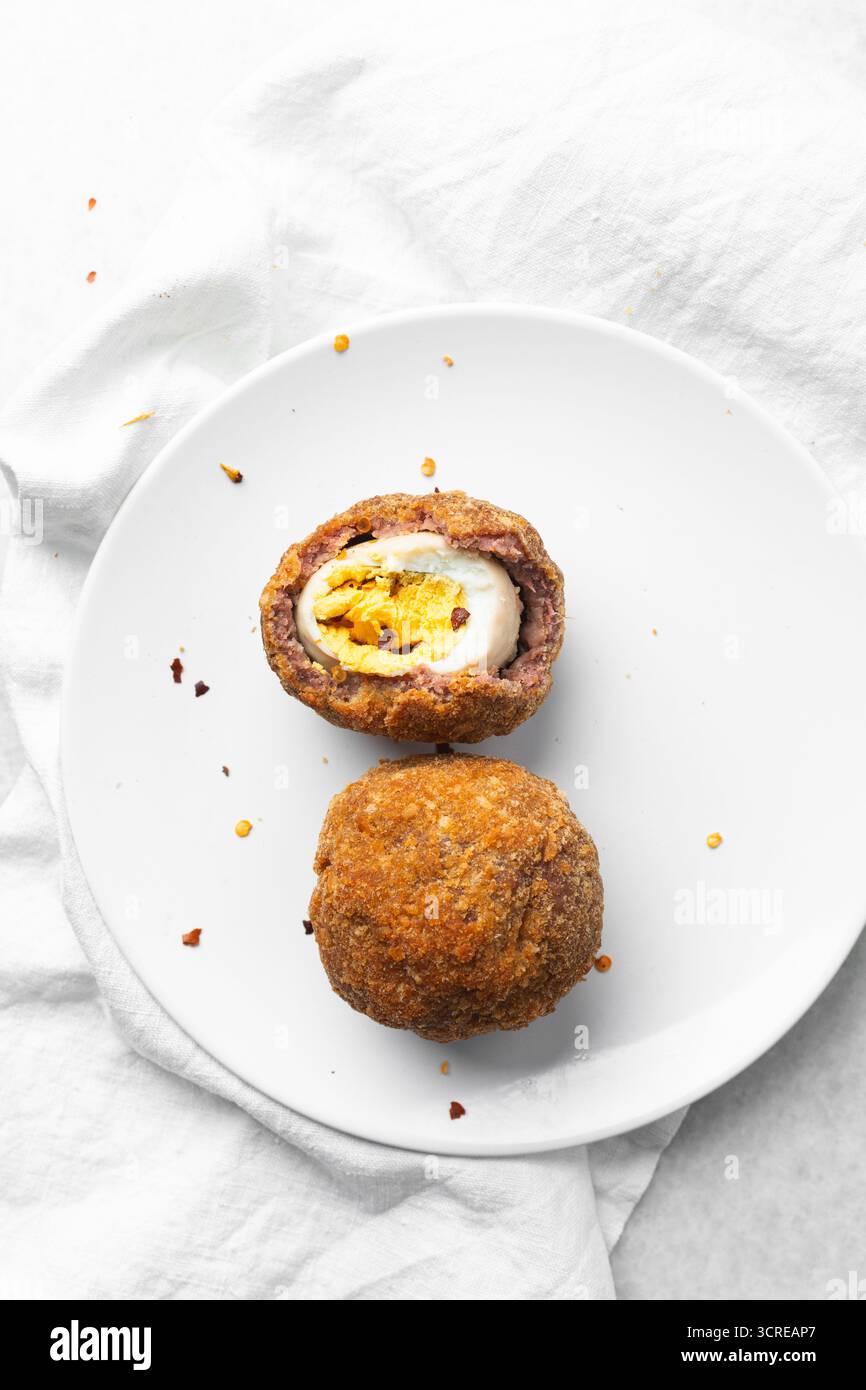 Vue aérienne des œufs de scotch frits sur le comptoir blanc, vue de dessus de la coupe transversale des œufs de scotch Banque D'Images