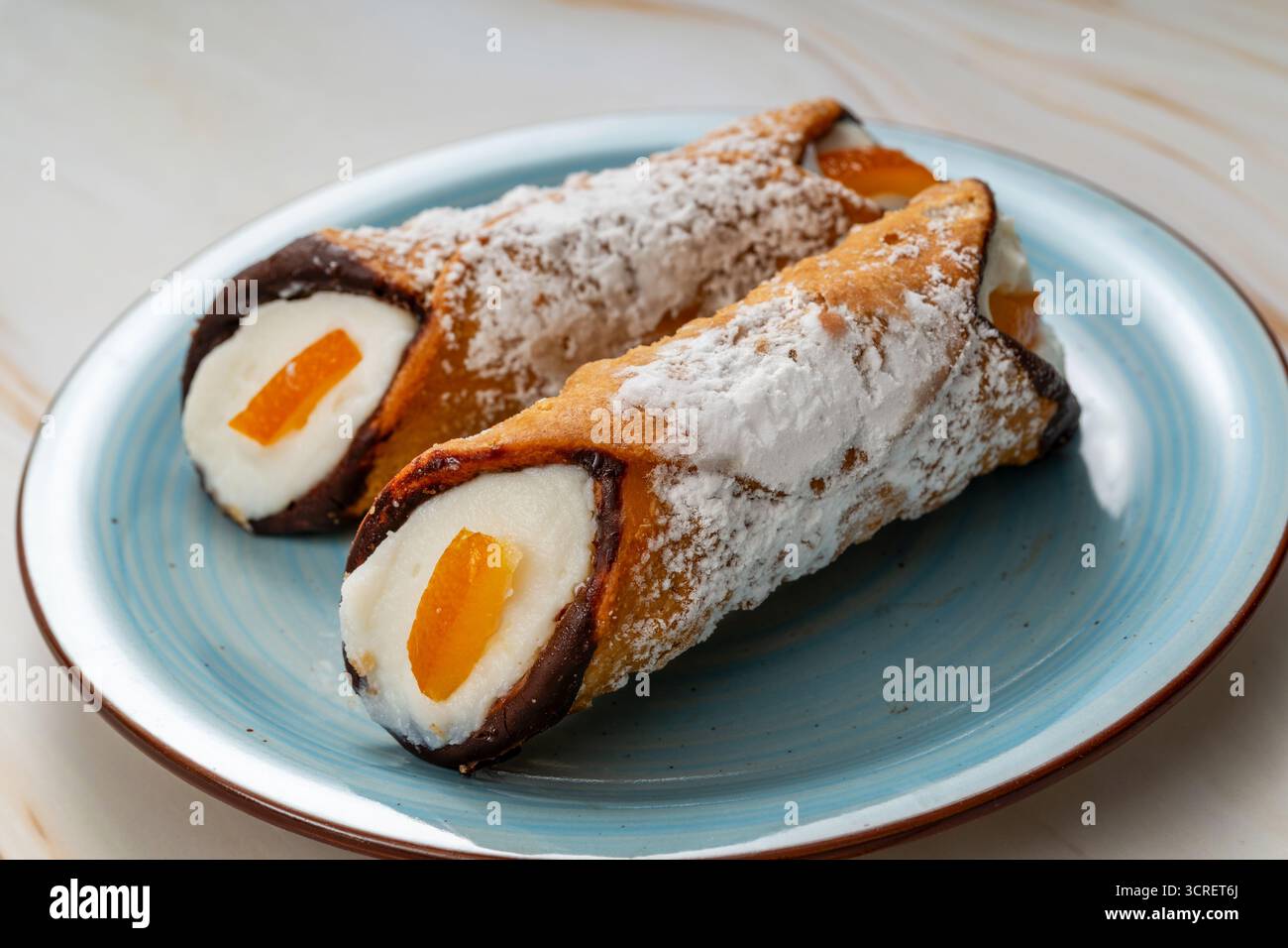 Cannoli sur une assiette, fourré de crème au fromage ricotta et de zeste d'orange confite Banque D'Images