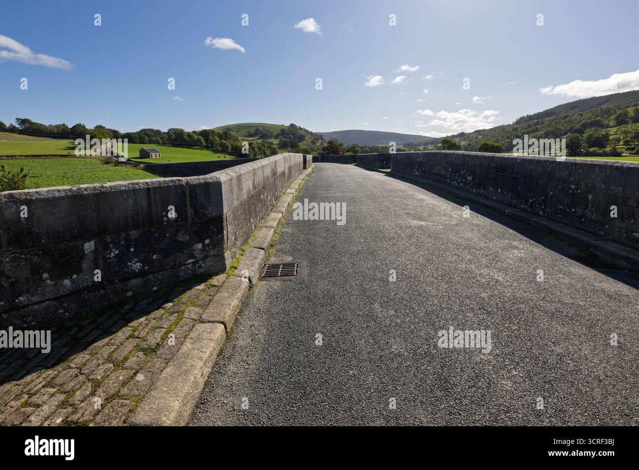 Le pont historique sur la rivière Wharfe à Burnsall dans le parc national des Yorkshire Dales en Angleterre par une journée ensoleillée avec le ciel bleu et les nuages. Banque D'Images