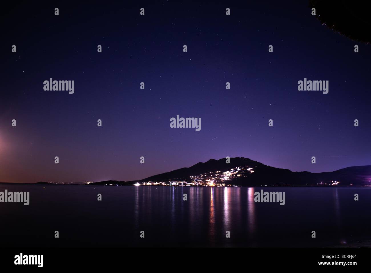 Paysage urbain nocturne avec reflets marins et horizon éclairé Banque D'Images