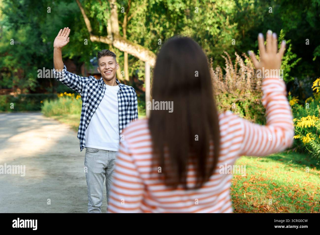 Femme saluant au revoir à son ami dans le parc, focalisation sélective Banque D'Images