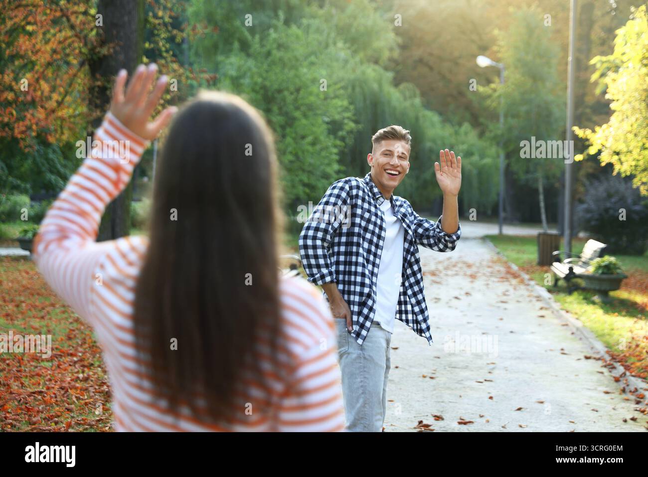 Femme saluant au revoir à son ami dans le parc, focalisation sélective Banque D'Images