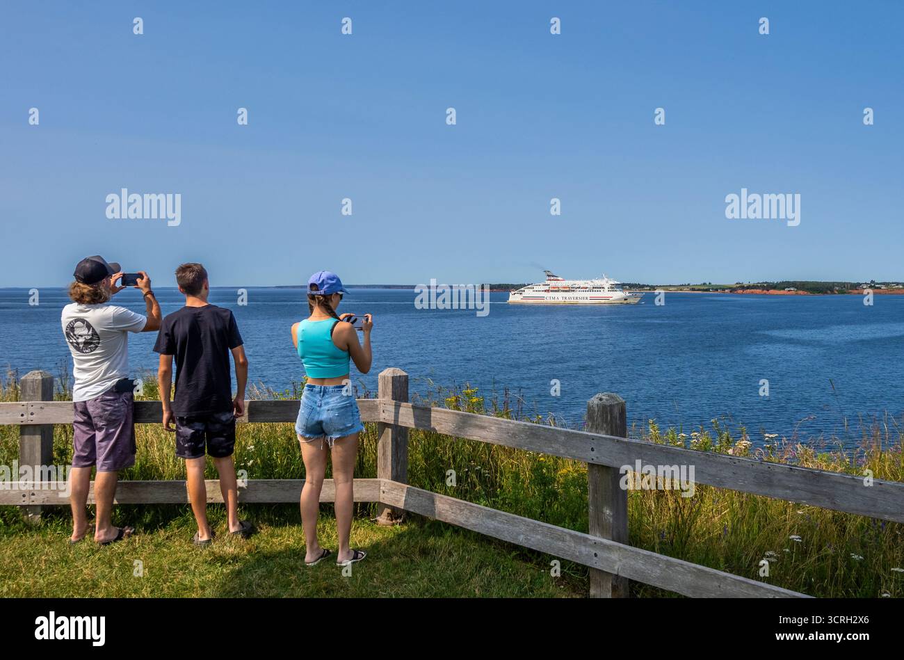 Trois personnes regardant CTMA Ferry arriver à souris sur l'Île-du-Prince-Édouard au Canada Banque D'Images
