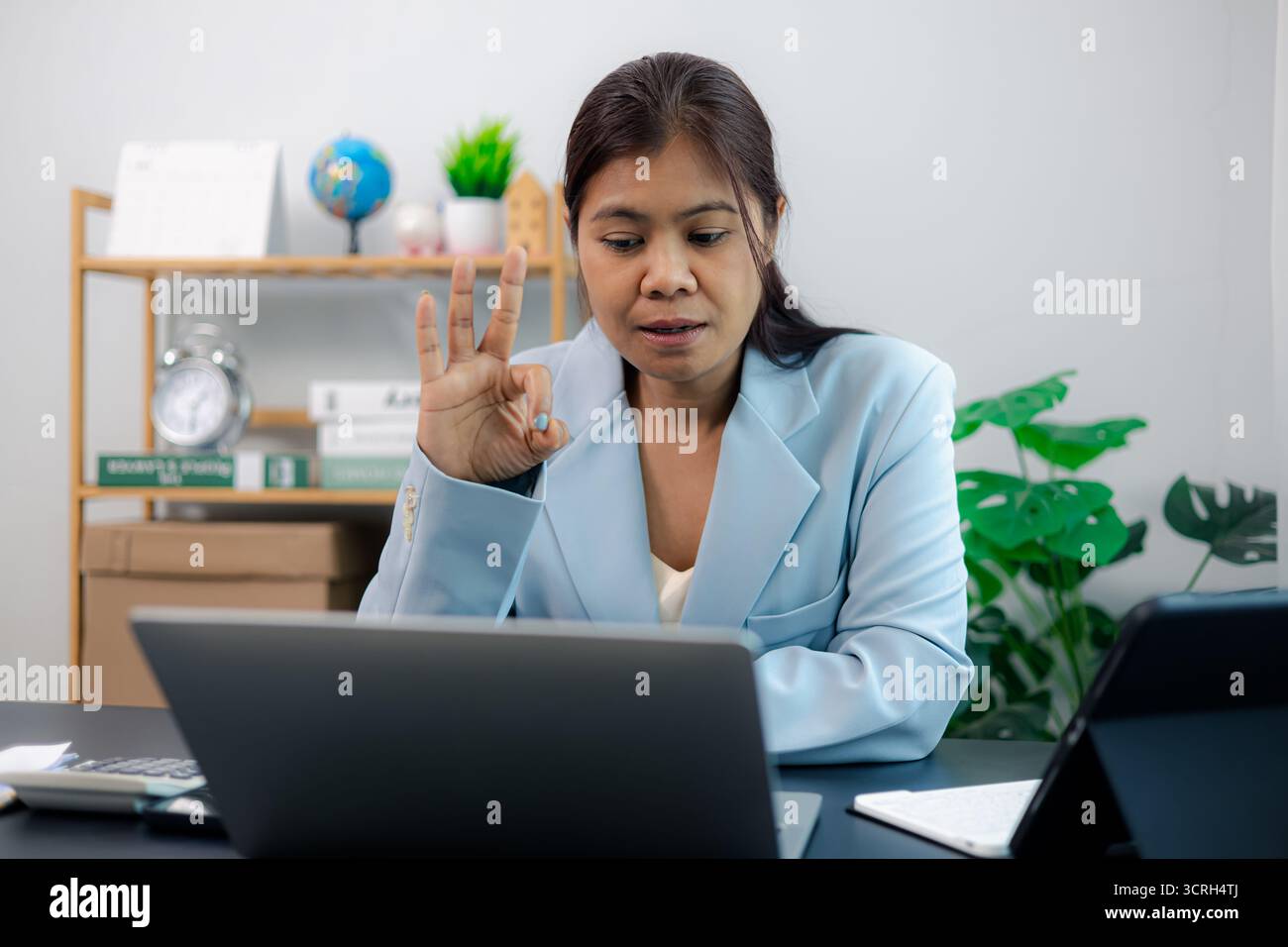 Femme d'affaires asiatique professionnelle donne OK geste de la main pendant la réunion virtuelle, montrant l'accord et la satisfaction. Symbole de communication claire, équipe Banque D'Images
