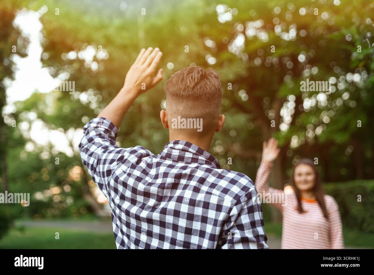Femme saluant au revoir à son ami dans le parc, focalisation sélective Banque D'Images