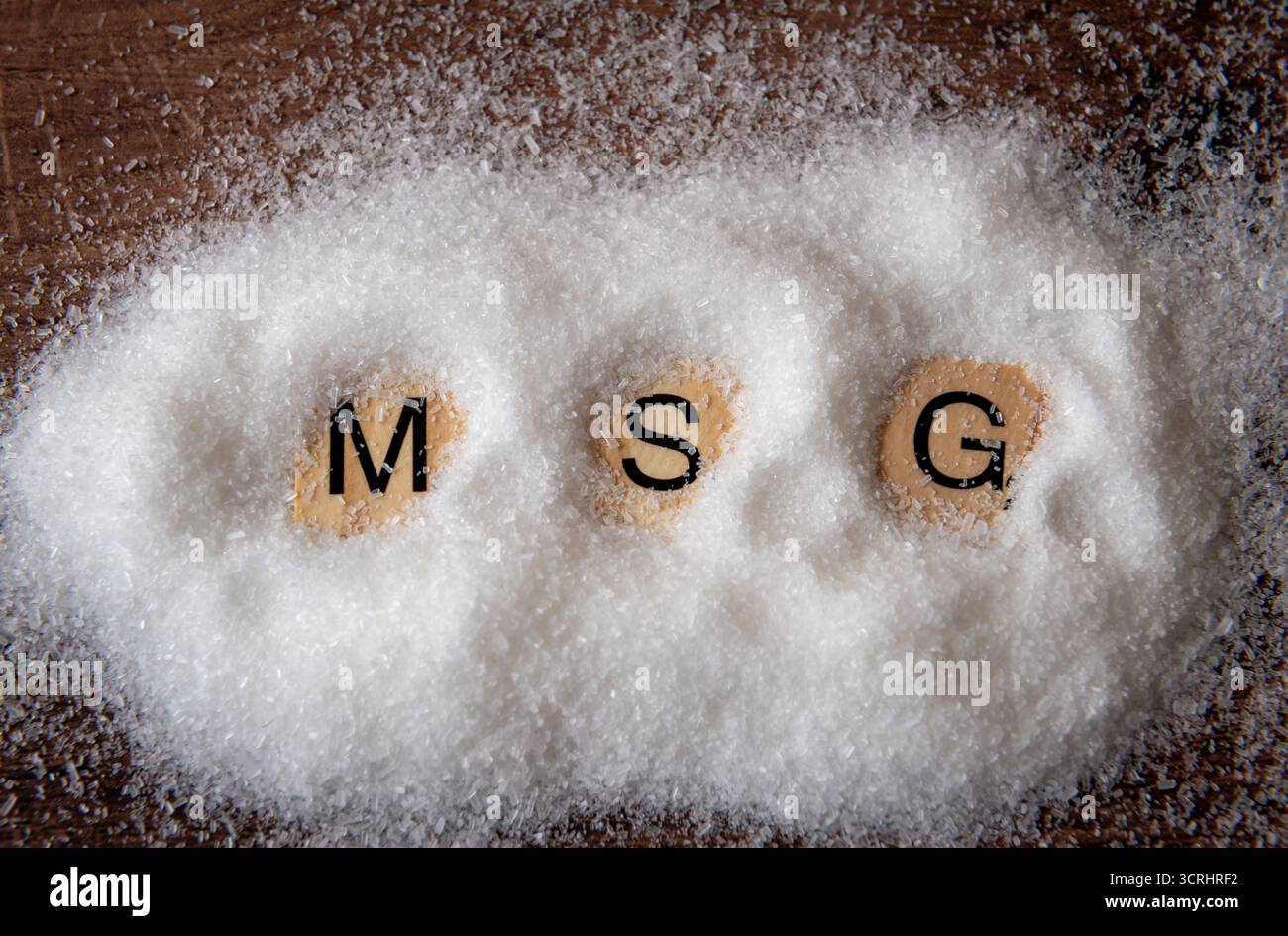 Gros plan d'un tas de glutamate monosodique avec les lettres M S G. Banque D'Images