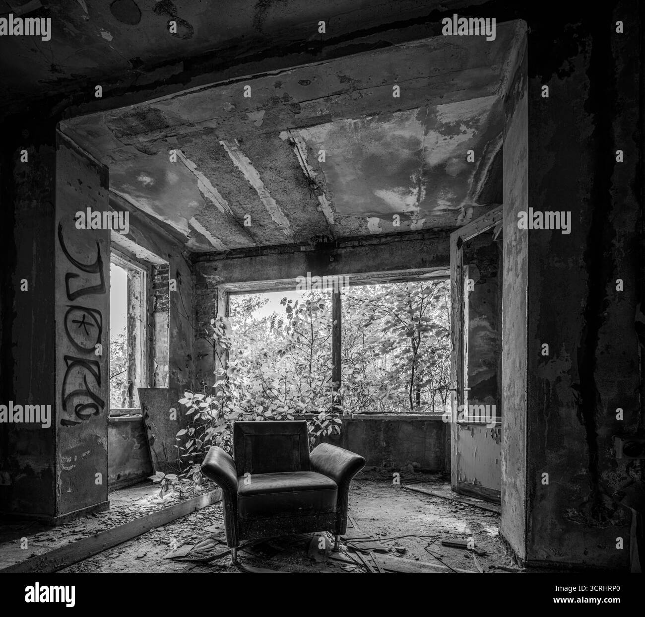 Chambre abandonnée avec fauteuil Vintage et canapé près de la fenêtre cassée, photographie d'exploration urbaine avec lumière naturelle Banque D'Images