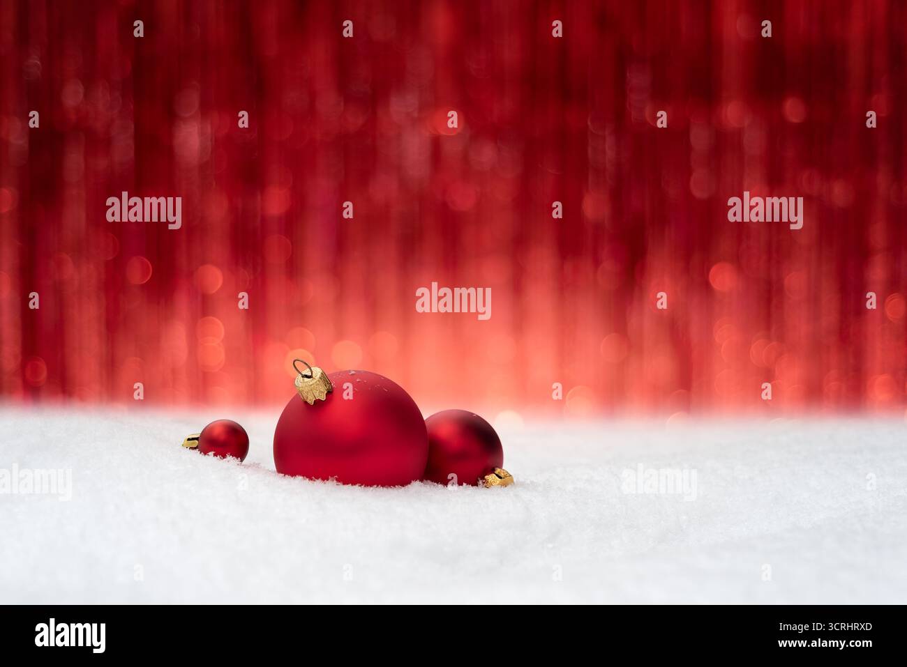 Fond de Noël avec des boules rouges sur la neige contre fond rouge festif avec espace de copie pour la conception Banque D'Images