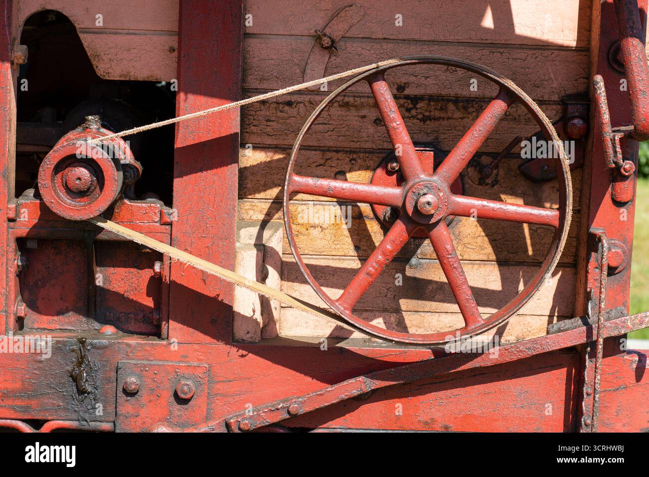 Gros plan sur une batteuse ou batteuse traditionnelle rouge et rose en bois au Devon County Show, mai 2025 à Exeter, Royaume-Uni Banque D'Images